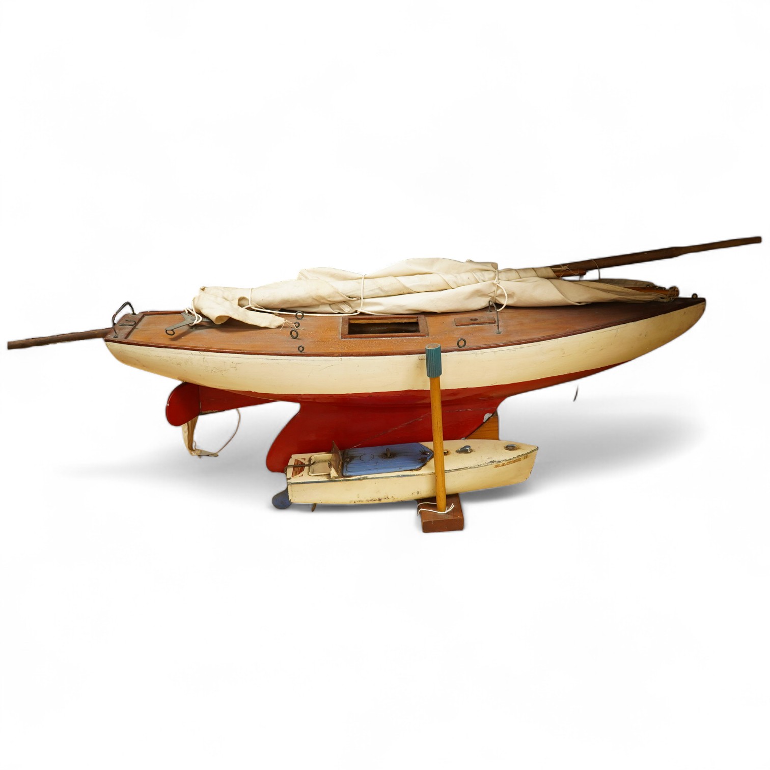 An early to mid 20th century pond yacht of wooden construction with lead weighted draft, hull length 74.5cm, together with a clockwork Hornby speedboat ‘Racer III’. Condition - poor to fair.